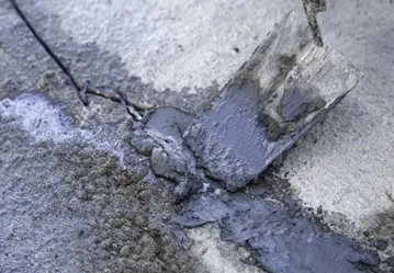 This image shows cracks in a pool area that is being repaired