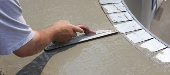 This image shows a man resurfacing a cement floor.