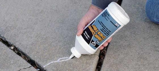This image shows a man repairing a crack on a pool deck.