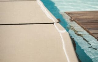 This image shows a npool deck that was resurfaced because of cracks.